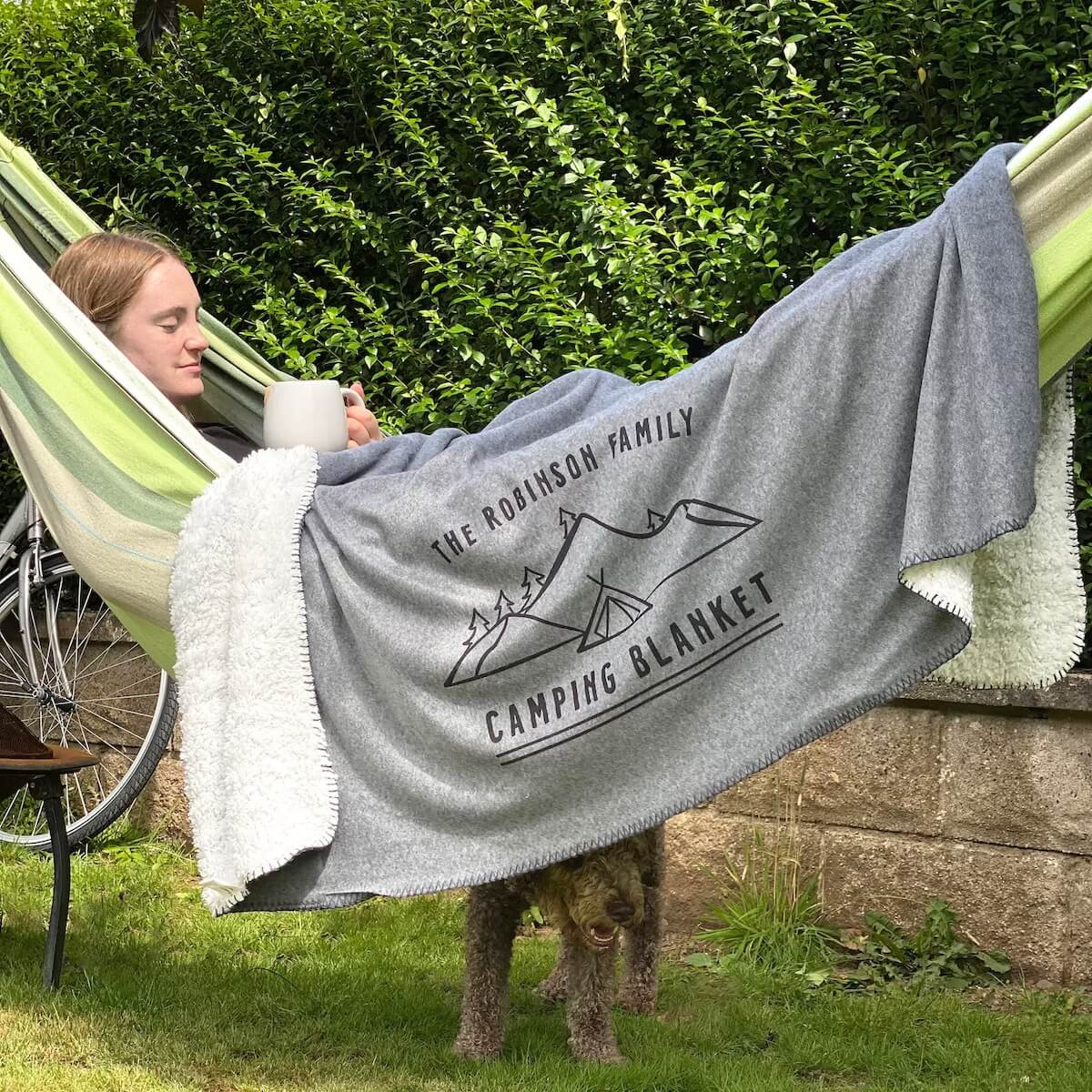 personalised camping blanket drapped over woman in hammock.