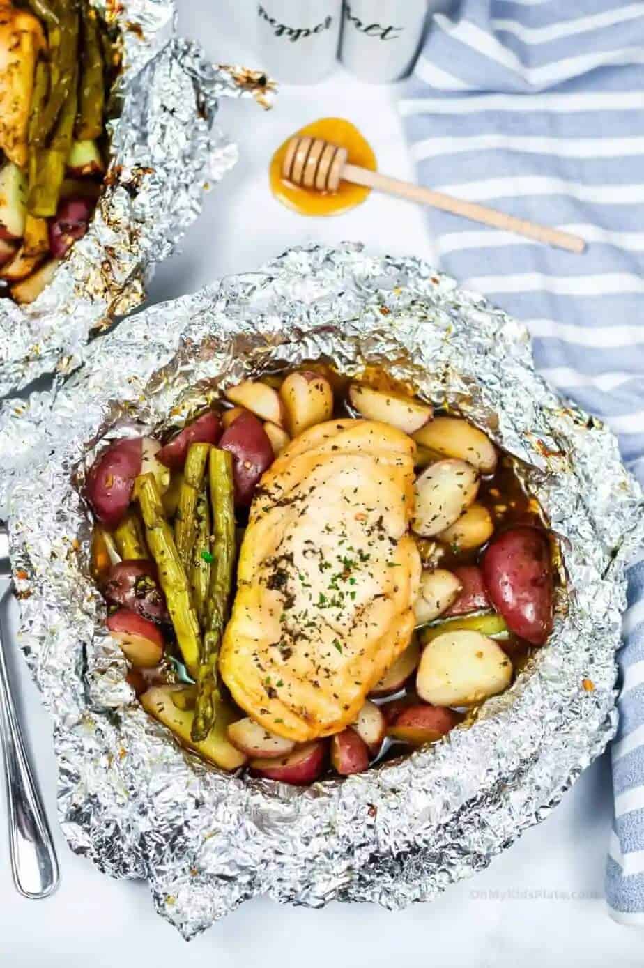 chicken and potatoes in an open foil packet after cooking in the campfire.