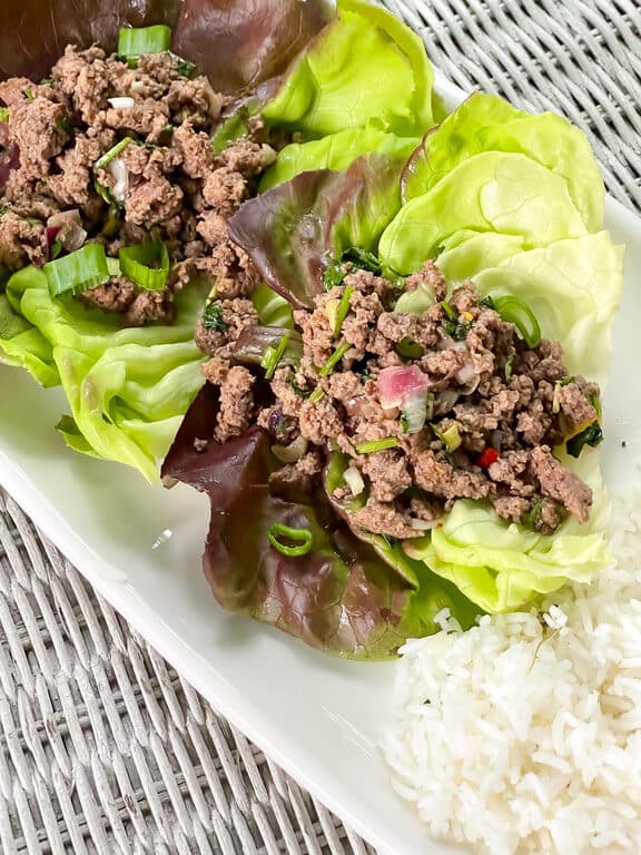 lettuce wrapped ground meat on a white plate.