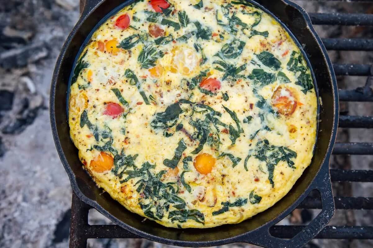 close up of skillet fritata over campfire grill.