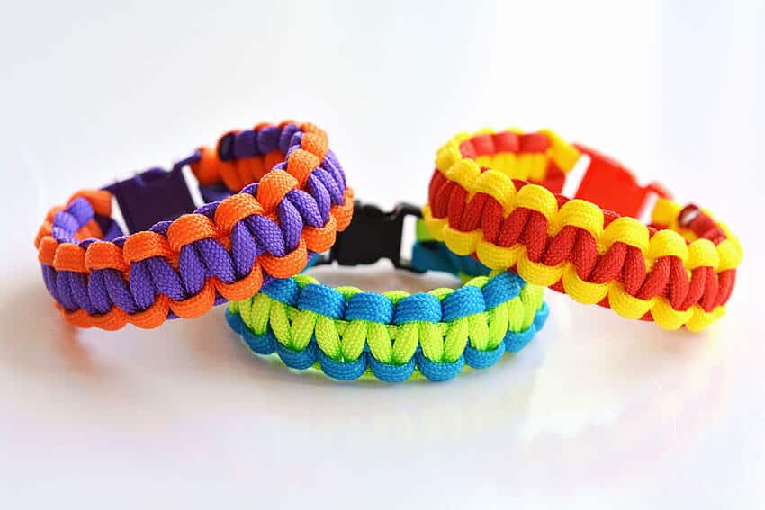 3 paracord bracelets in different colours on white background.