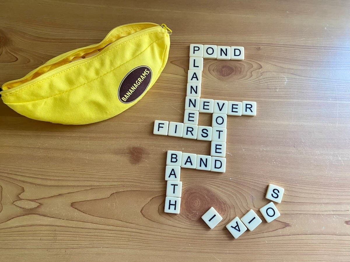 bananagrams game on a wooden table with tiles laid out.