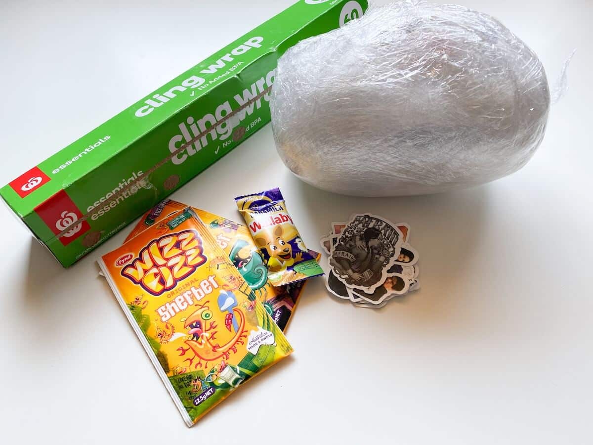 saran wrap ball with cling wrap and prizes next to it.