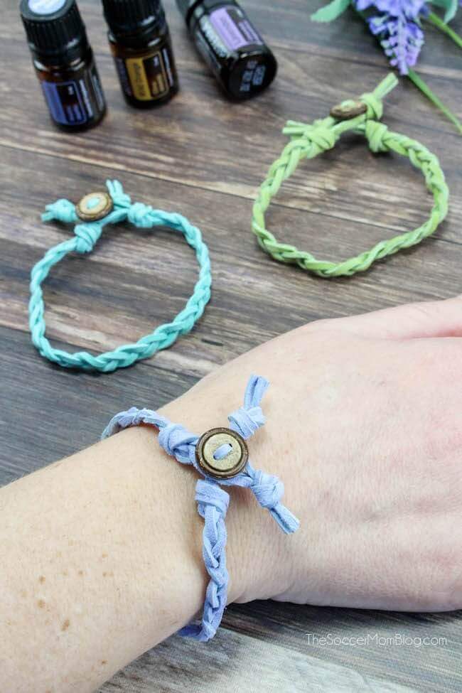 close up of woman's wrist with leather bracelet and essential oils in background.