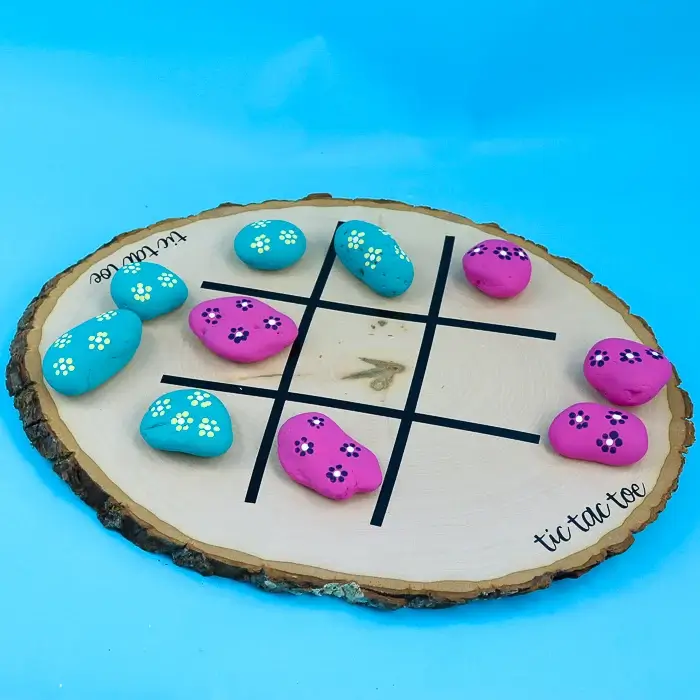 wood slice tic tac toe board with painted rocks.