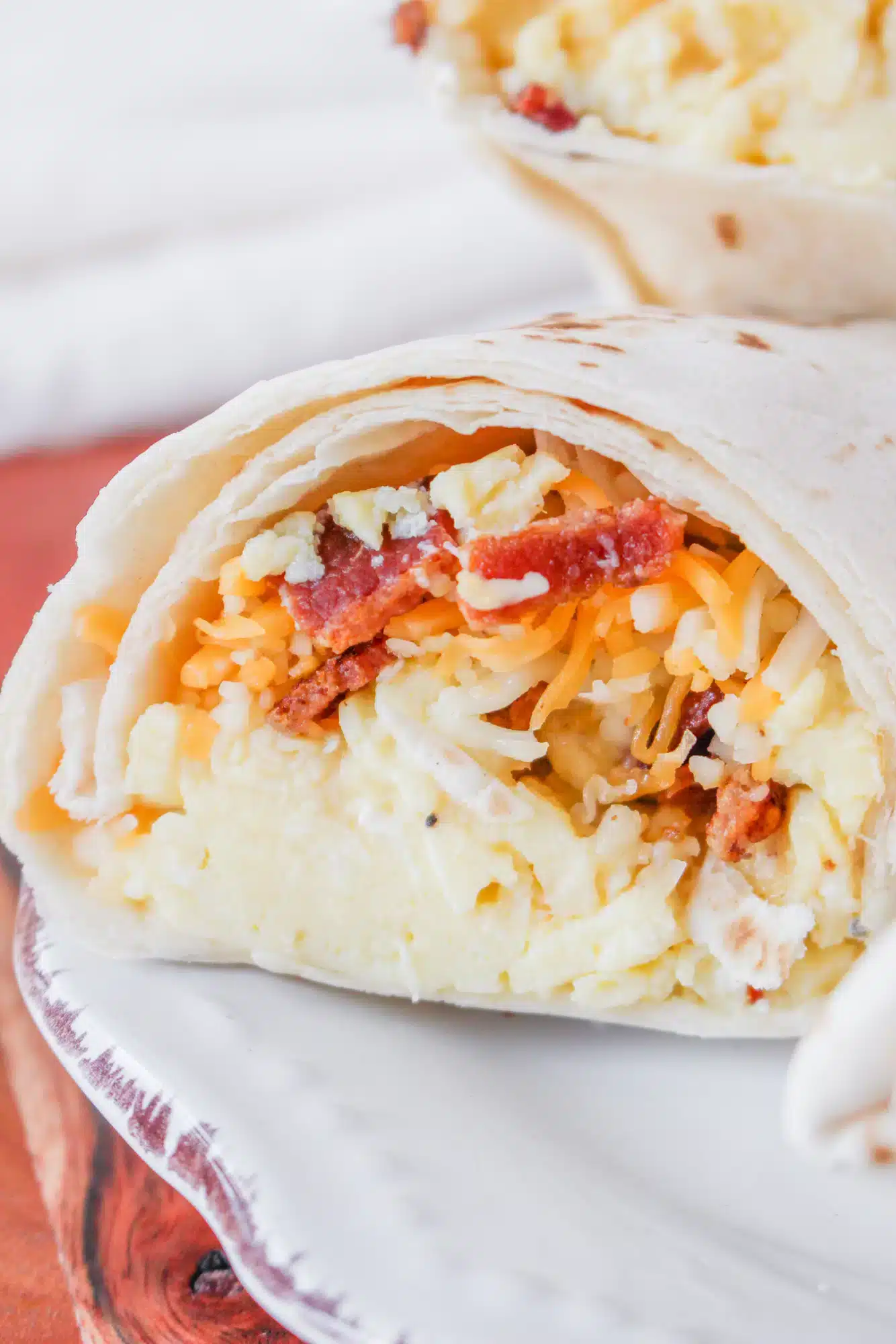 close up of a breakfast burrito on a plate.