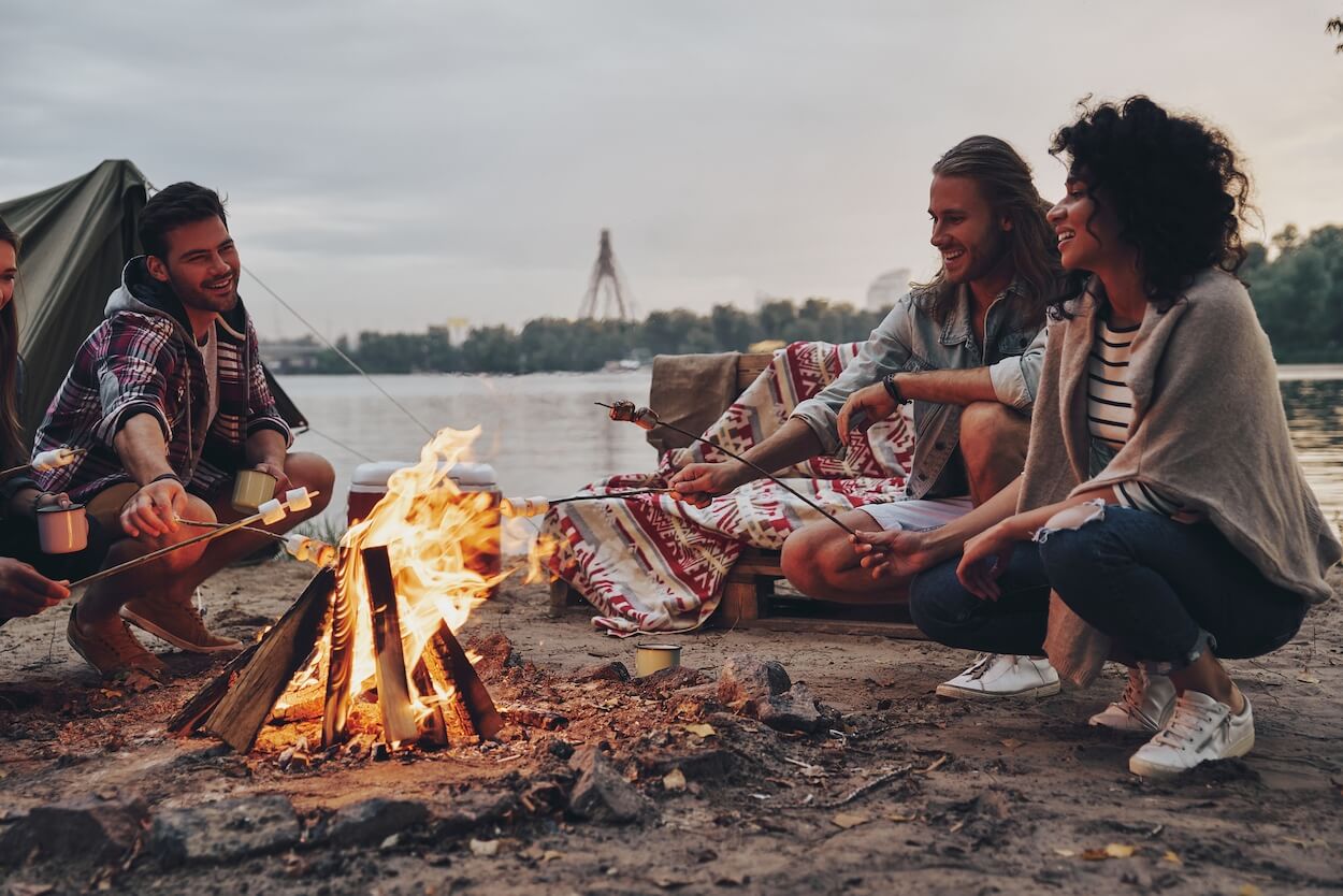 group of friends sitting around campfire.