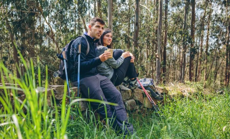 man and woman resting during a hike with a snack.